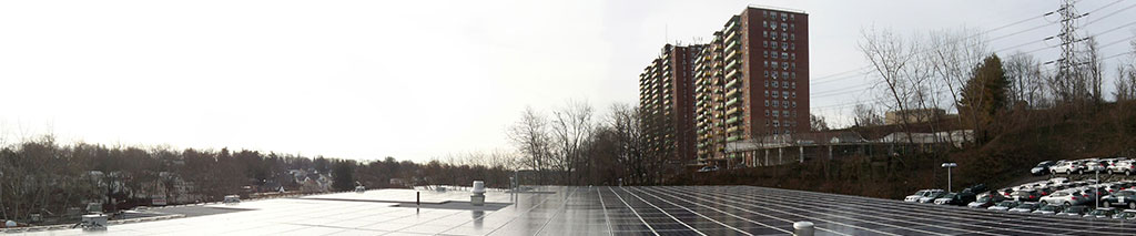 commercial roof top solar array with city in the background